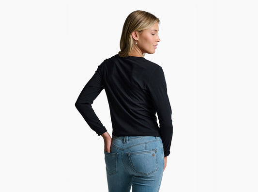 Woman wearing a black long-sleeve top and blue jeans on a white background