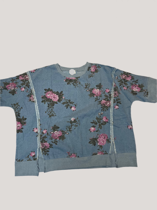 Blue tank top with floral pattern on a textured surface